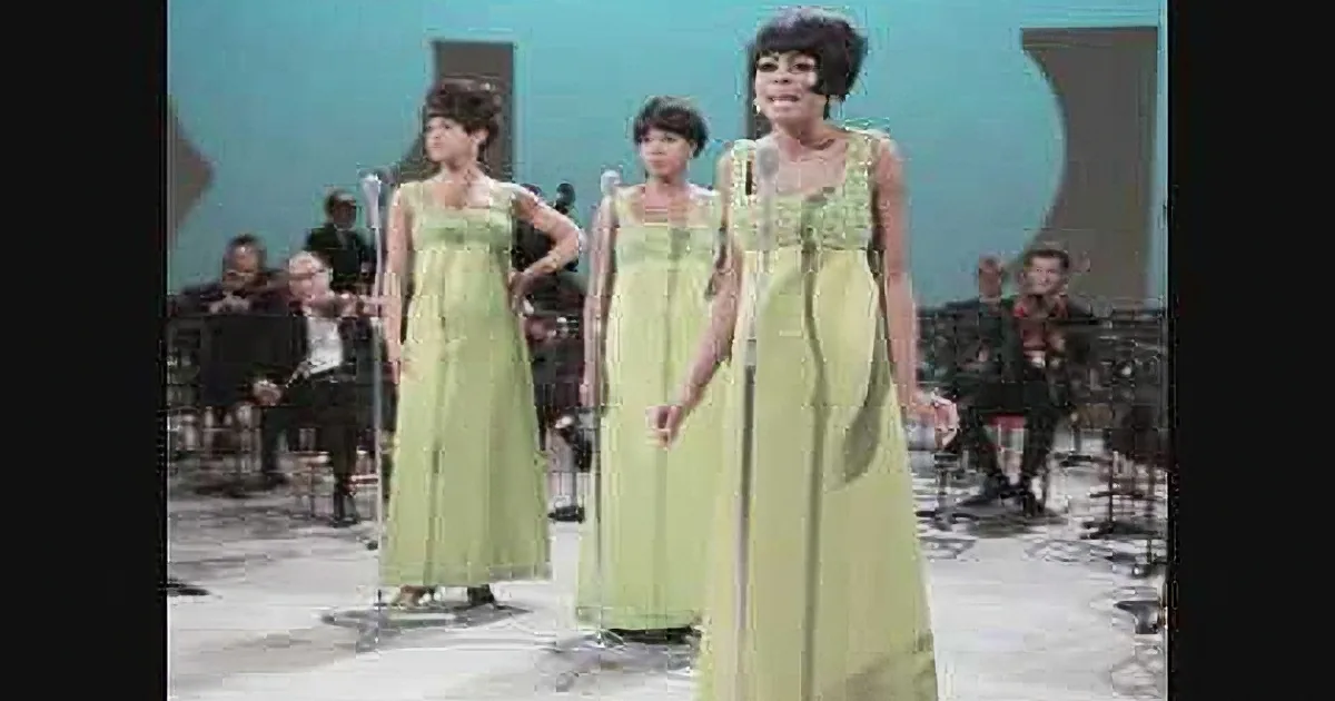 Five young musicians perform on stage, each with a unique outfit and instrument, under vibrant lighting.