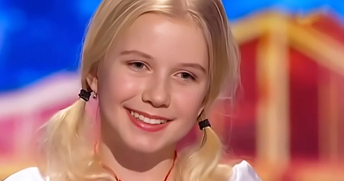 A smiling child with blonde hair, wearing earrings, and a white top, set against a colorful background.