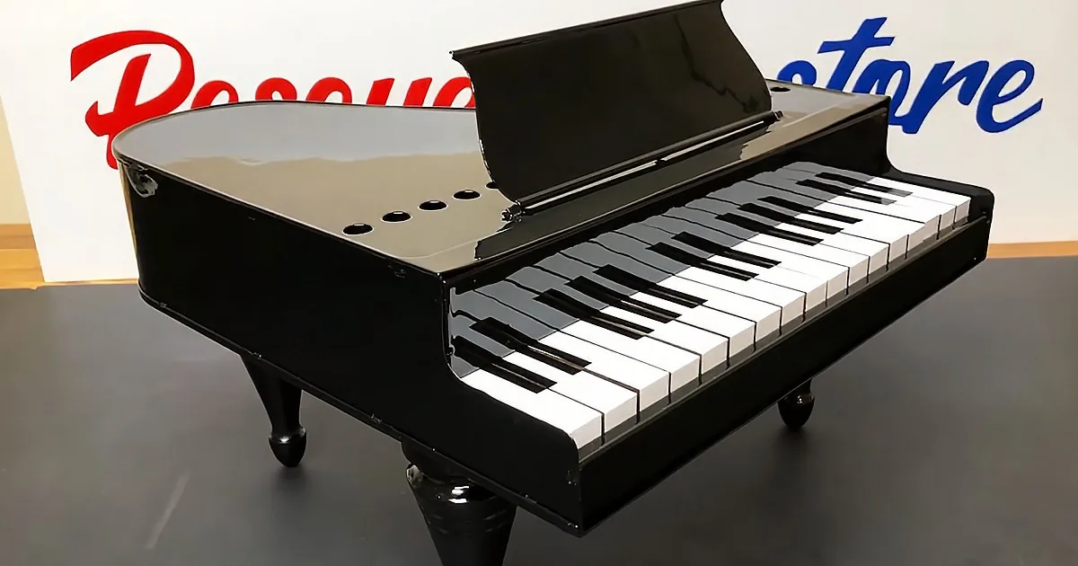 A black baby grand piano with open lid and white and black keys is displayed in front of a "Piano Store" sign.