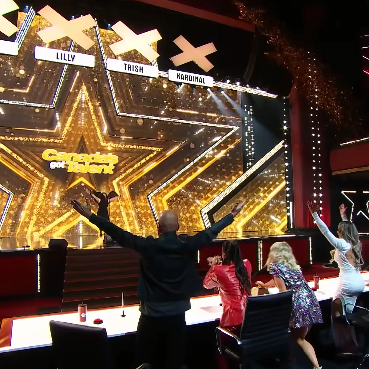 A judge raises his arms in excitement on the "Canada's Got Talent" stage.