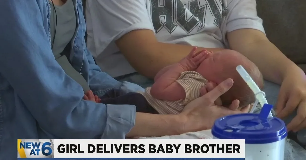 A newborn baby is being held and comforted by a person in a white shirt and blue jeans.
