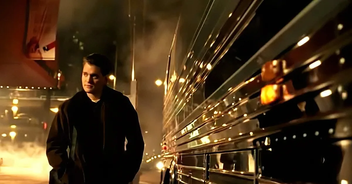A man stands on a dimly lit street, facing a reflective bus with golden lights, creating a dramatic and mysterious...