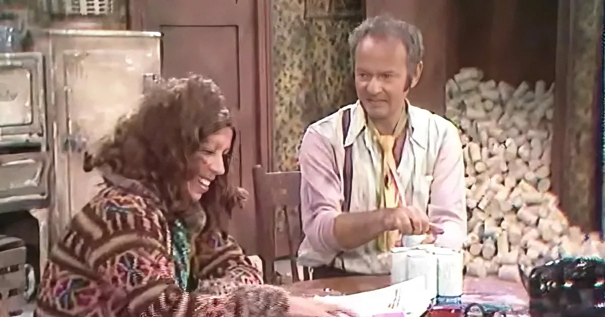A man and woman are seated at a table, with the man pouring something into a cup while the woman looks on.