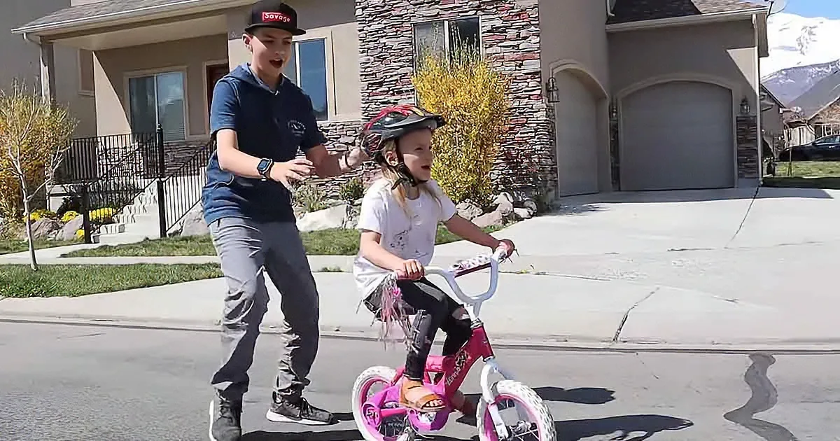 Devoted Older Brother Teaches Fearless Little Sister to Ride a Bike