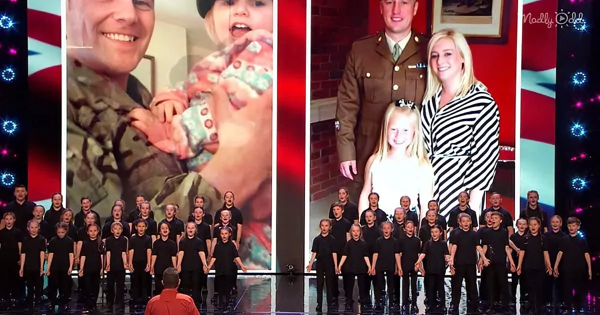 A group of children in black shirts stands in front of a large screen displaying family photos.