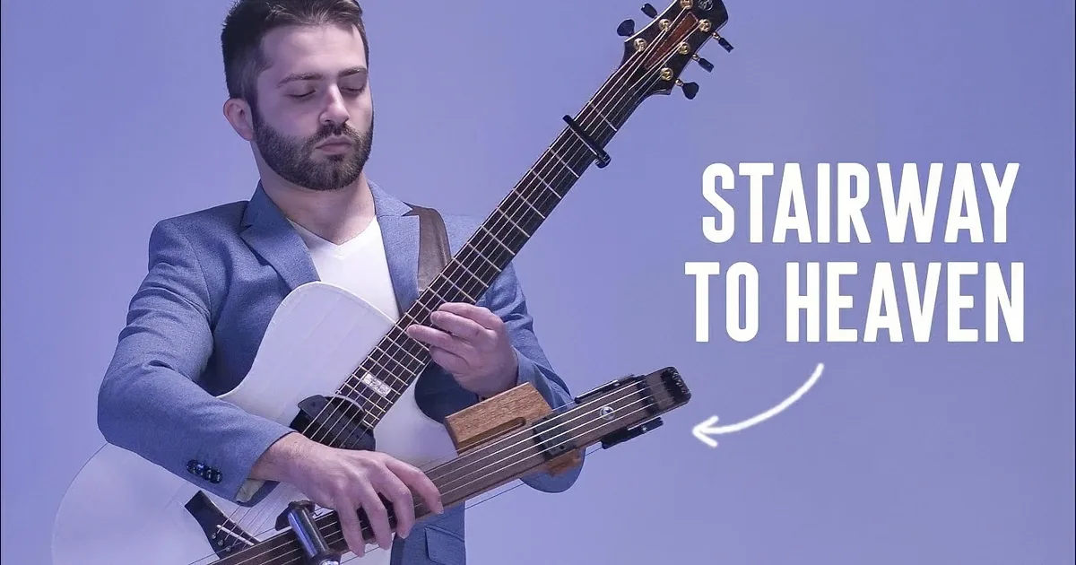 A man in a blue suit plays a guitar with a unique electronic attachment.