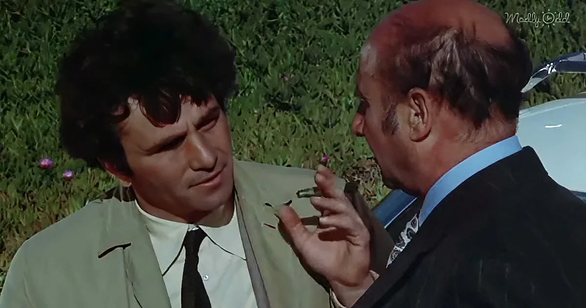 A man in a suit adjusts another man's jacket while both are outdoors near a car.