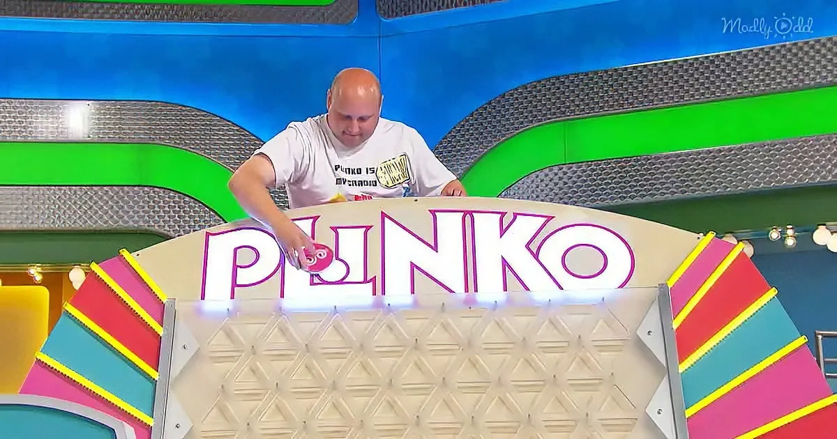 A man plays Plinko, placing a ball on the game board with colorful tracks and a large "Plinko" sign.