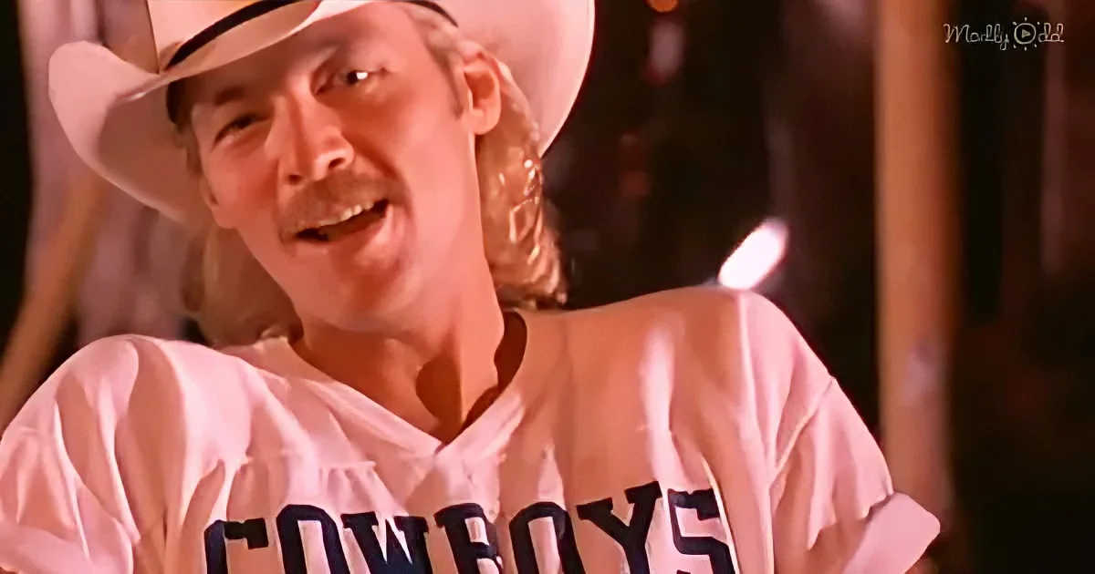 A man in a white cowboy hat and "Cowboys" jersey smiles warmly.