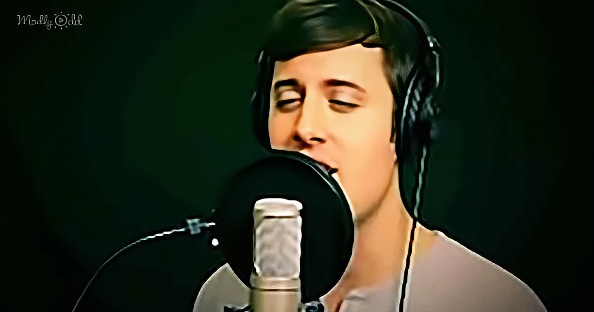 A person wearing headphones sings into a microphone against a dark background.