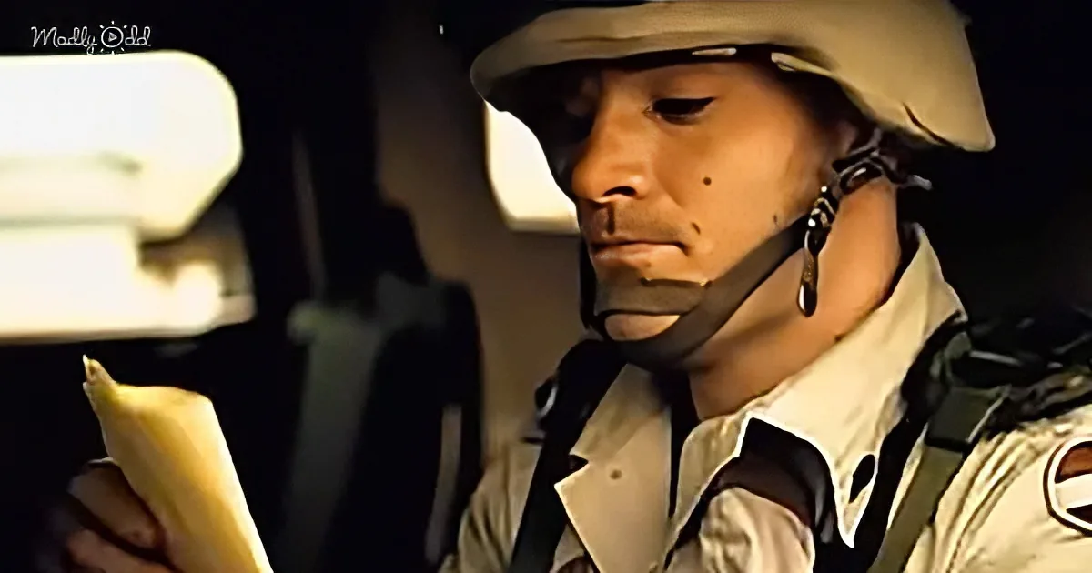 A person in military attire, wearing a helmet and holding a banana, is seated inside a vehicle.