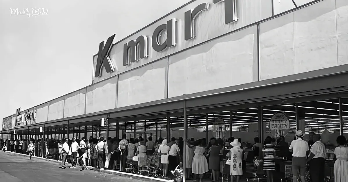 A Kmart store with a long line of people waiting to enter, dressed in mid-20th-century fashion.