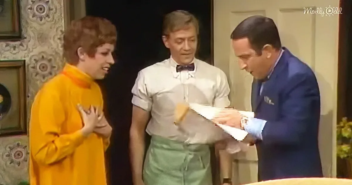 A man in a blue suit holds a piece of paper while another man in a white shirt and bow tie looks on, with a third person...