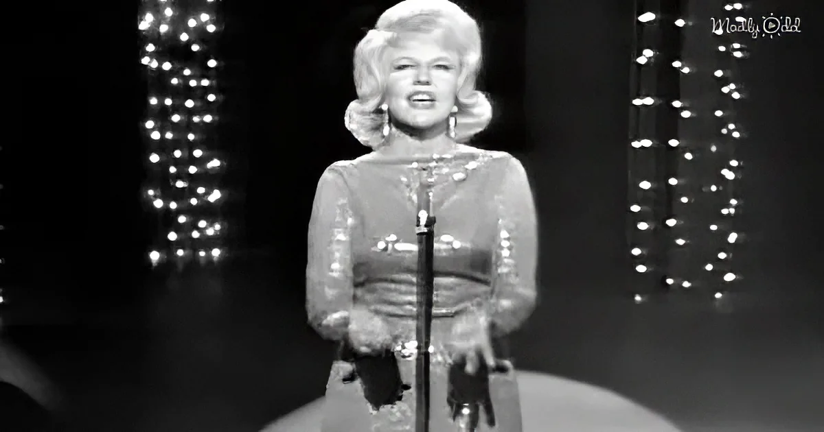 A woman in a sequined outfit sings on stage with a microphone, surrounded by twinkling lights.