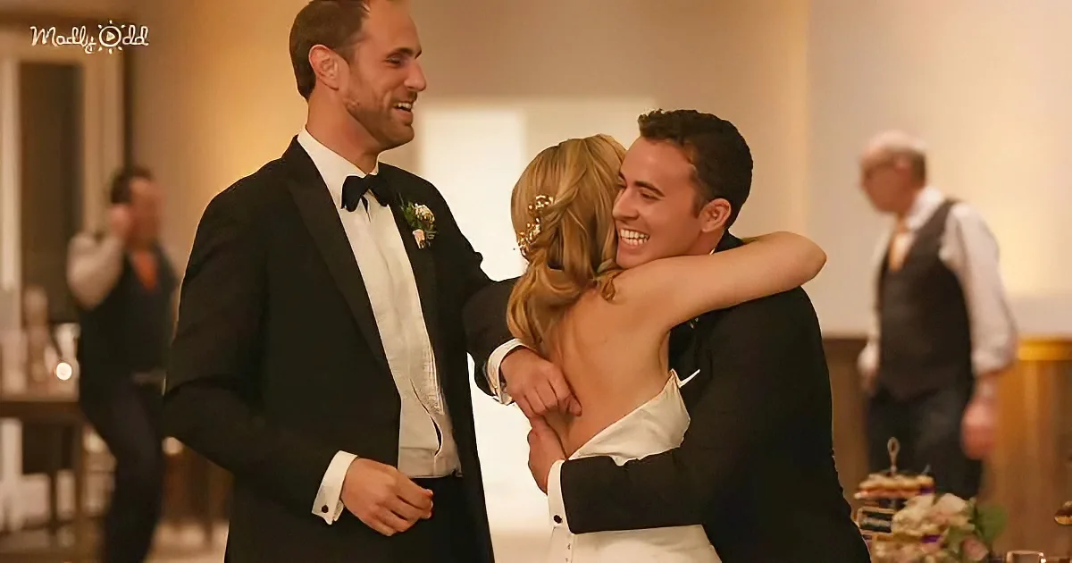 A bride and groom share a joyful embrace at a wedding reception, surrounded by guests.
