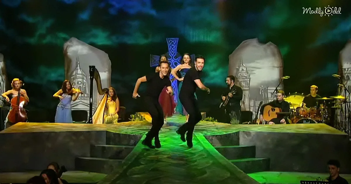 A couple dances energetically on a stage with musicians and a harpist in the background.