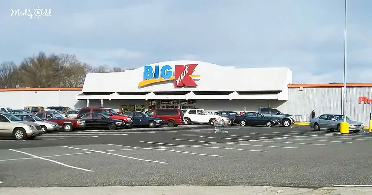 A Big Kmart store with a white facade and a parking lot filled with cars.