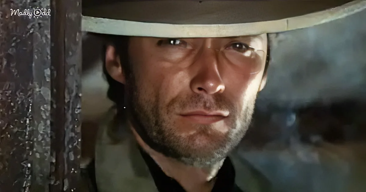 A man in a cowboy hat looks intense, framed by a metal structure, with a rugged expression.
