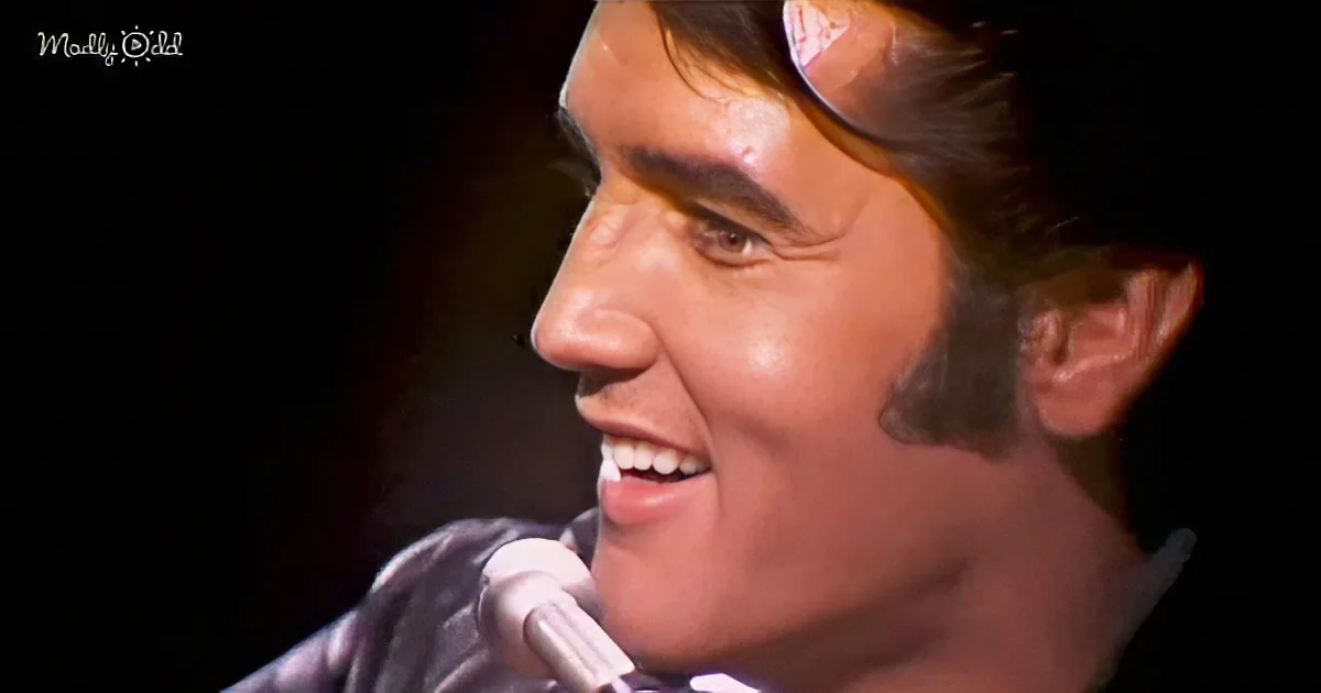 A smiling man with styled hair and a microphone, likely performing on stage.