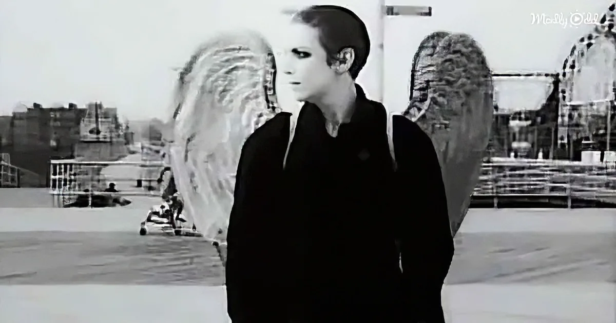 A person in a black outfit stands with angel wings, set against a cityscape backdrop.
