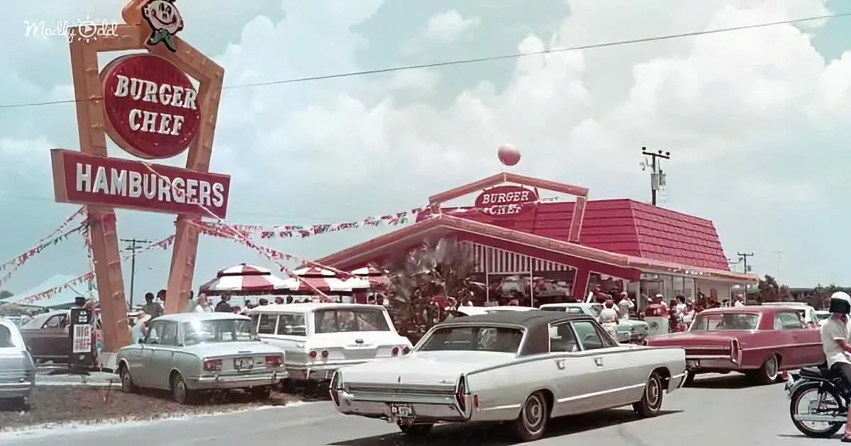 A Burger Chef restaurant with classic cars and people in a bustling parking lot.