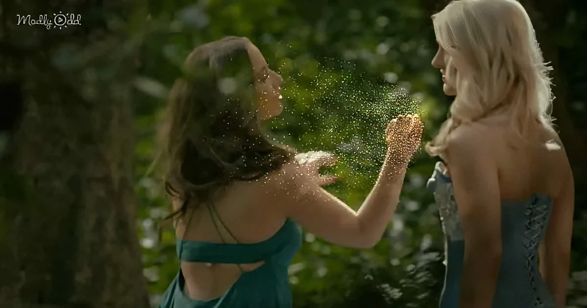 Two women in teal dresses face each other, sparkling glitter flying between them in a forest setting.