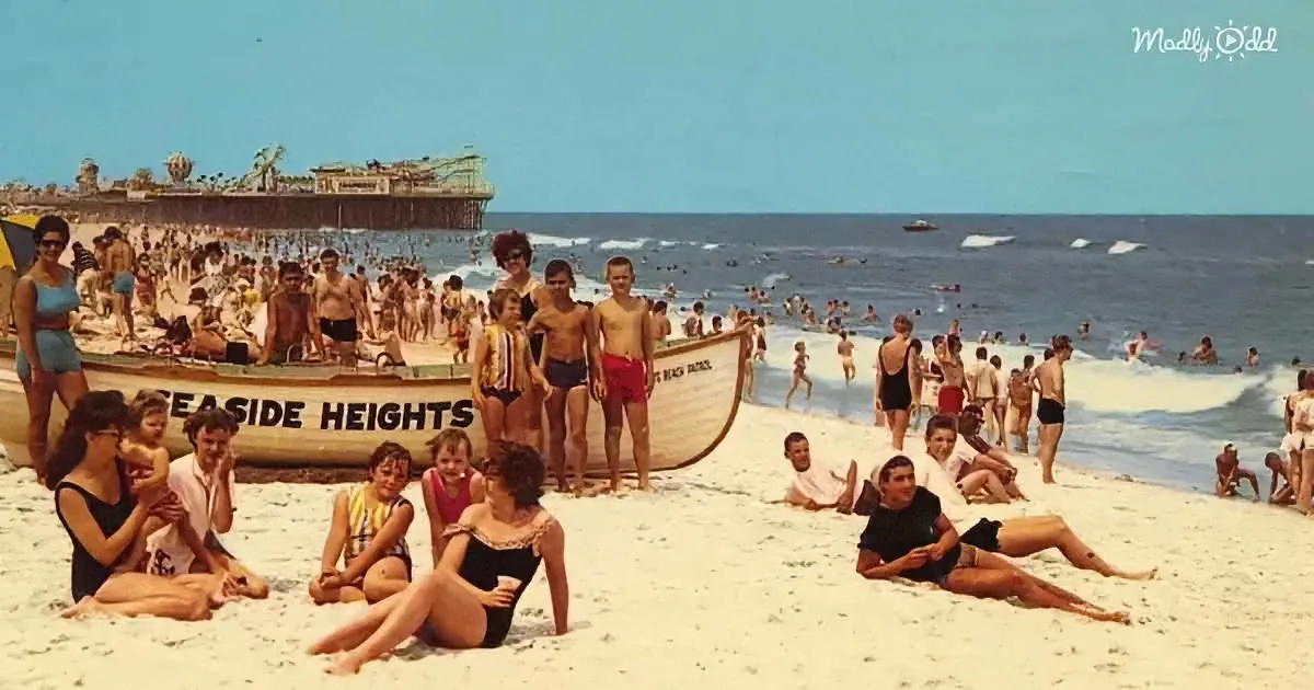 A lively beach scene with people in swimsuits, a lifeboat labeled "Seaside Heights," and a crowded pier in the background.