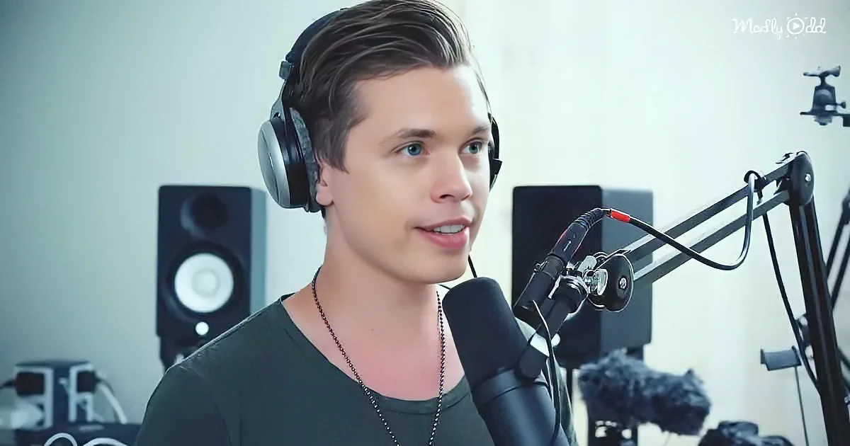 A person wearing headphones speaks into a microphone in a recording studio setup.