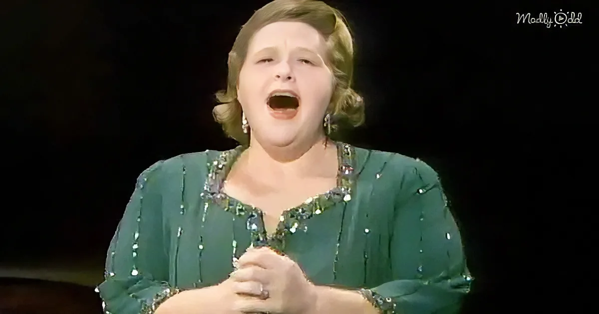 A woman in a green sequined dress sings passionately, holding a microphone.