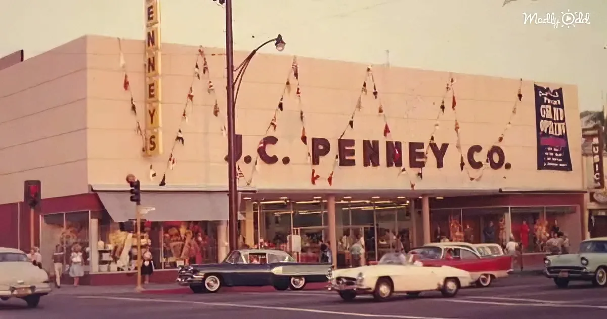 J.C. Penney Co. store facade with vintage cars and people in front, festive decorations.