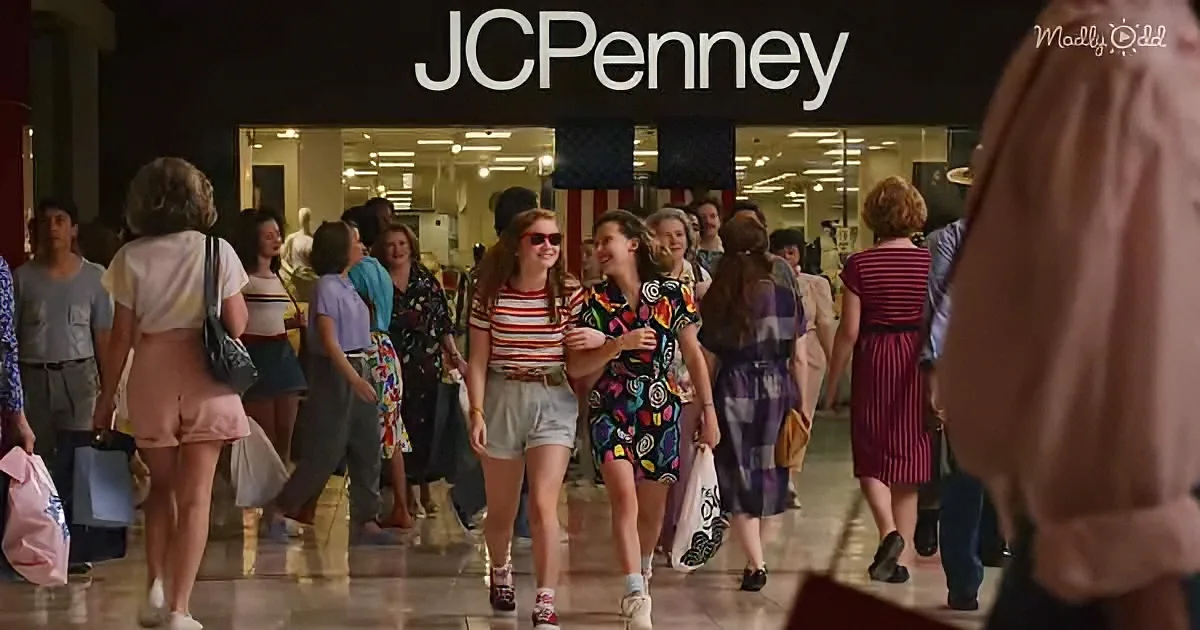 Two girls in colorful outfits walk through a crowded mall, smiling and holding hands.