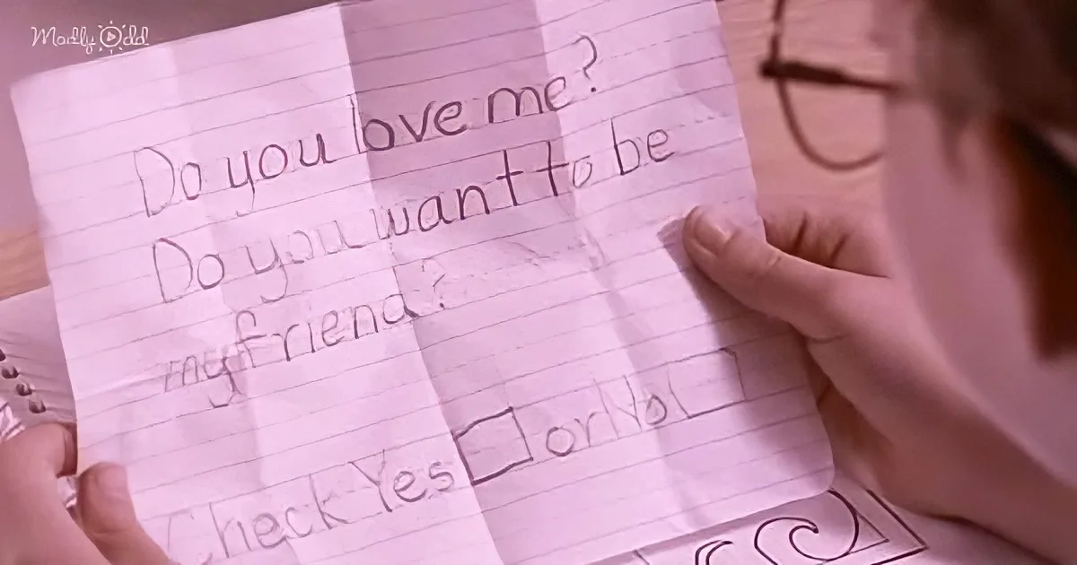 A person holds a handwritten note asking if someone loves them and wants to be friends, with a "Yes" or "No" checkbox.