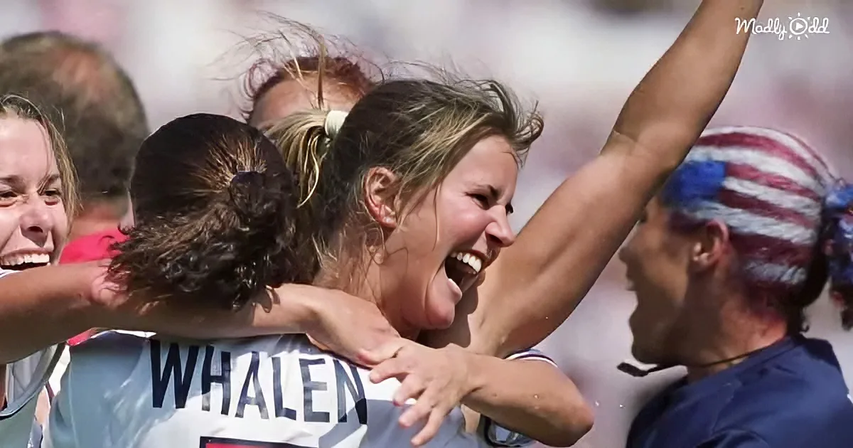 A soccer player with "Whalen" on her jersey celebrates with teammates, arms raised in joy.