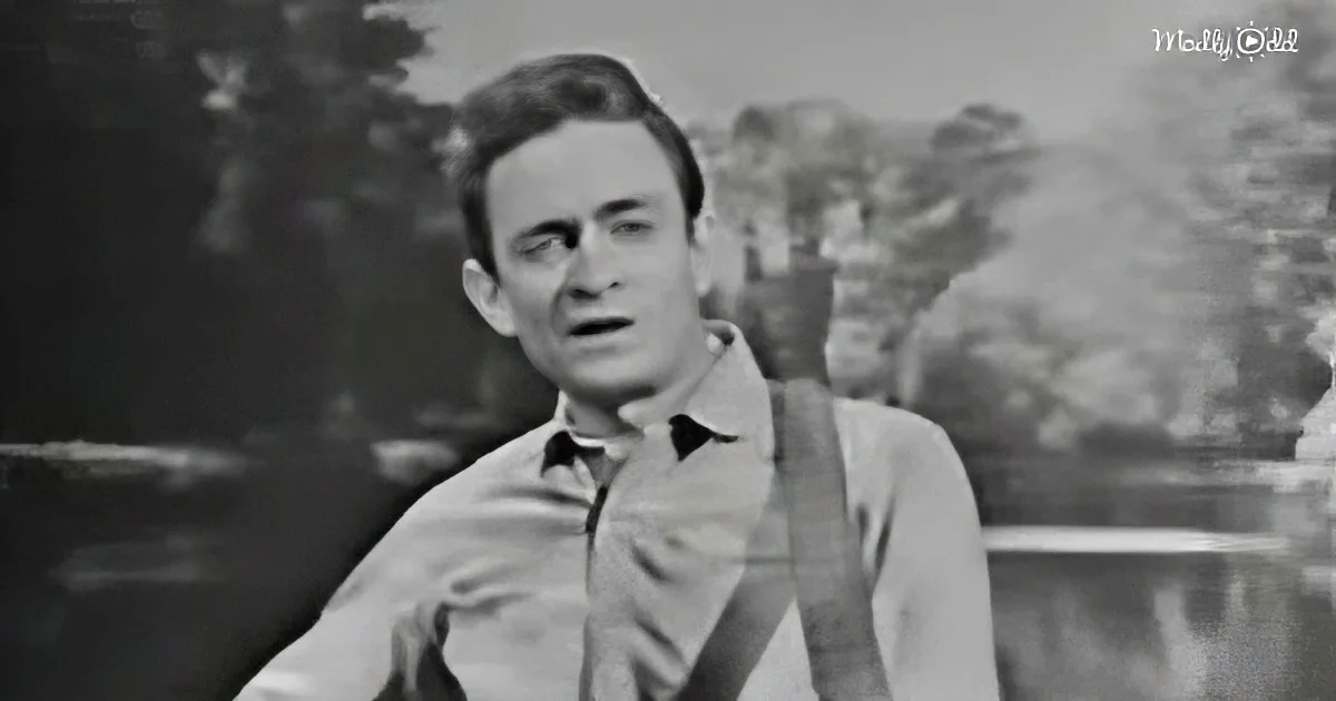A man in a light-colored shirt stands outdoors, gesturing with his right hand.