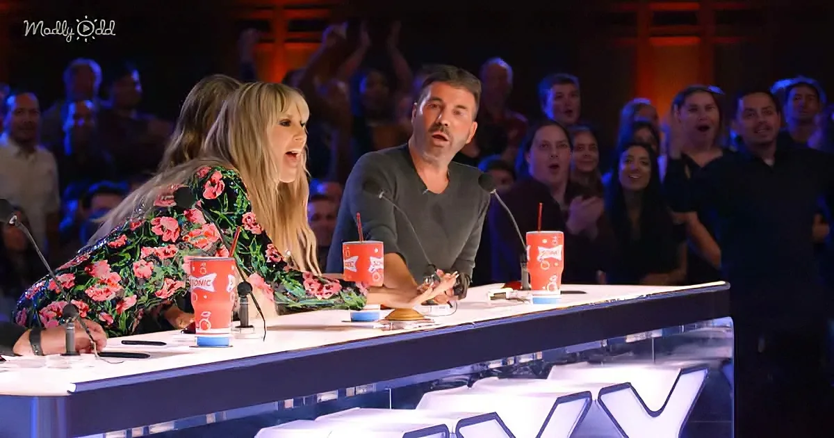 Two judges, one in floral, react with surprise at a talent show, audience clapping in the background.