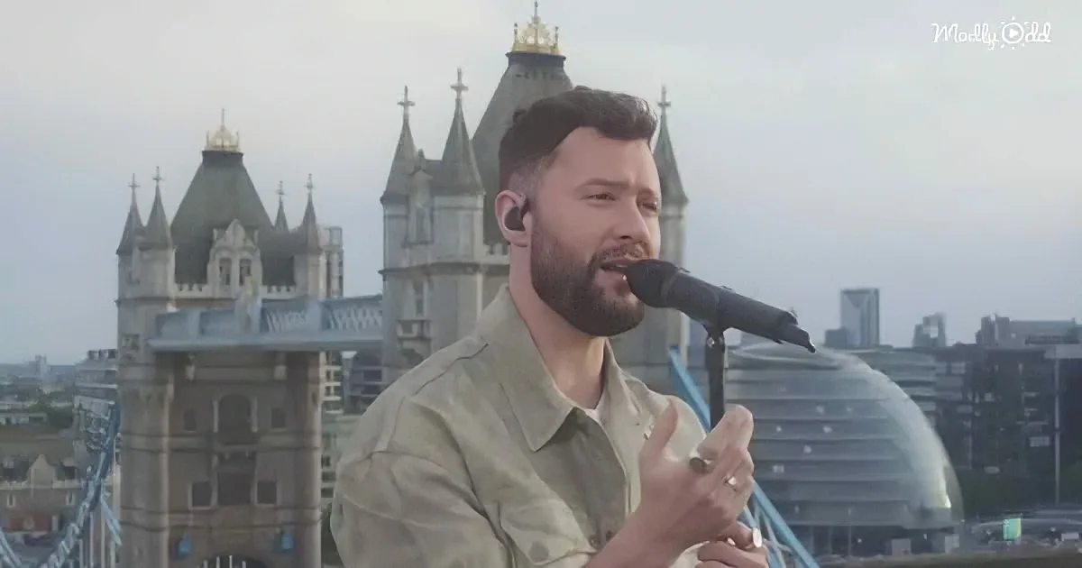 A man sings into a microphone with a backdrop of Tower Bridge and London's skyline.
