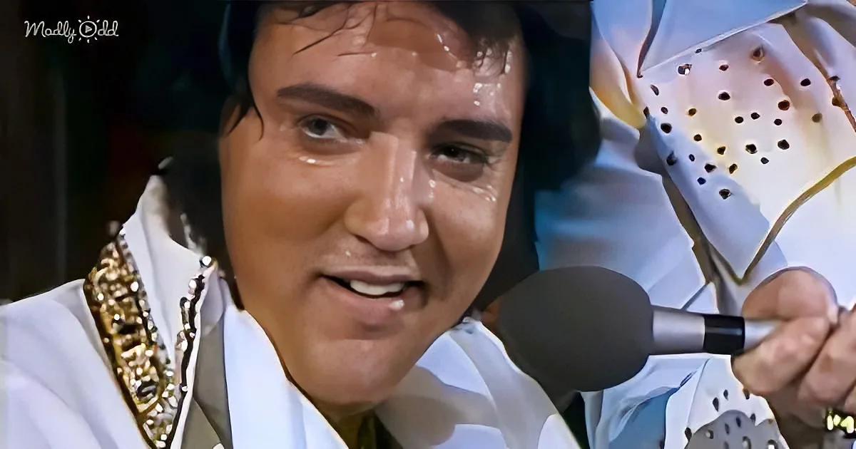 Elvis Presley in a white suit with a microphone, holding a piece of paper with holes.
