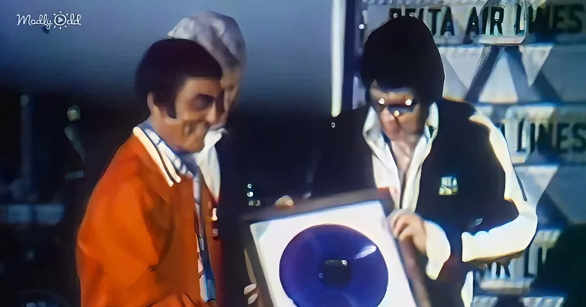 Two men in retro attire examine a large, old-fashioned radio in a dimly lit setting.