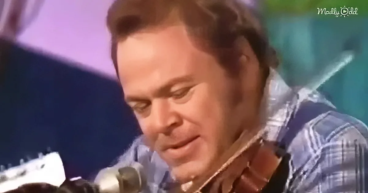 A man in a plaid shirt is playing a guitar and singing into a microphone.