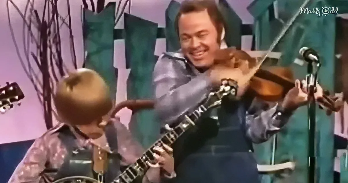 A man and a young boy play guitars on stage, both smiling and enjoying the performance.
