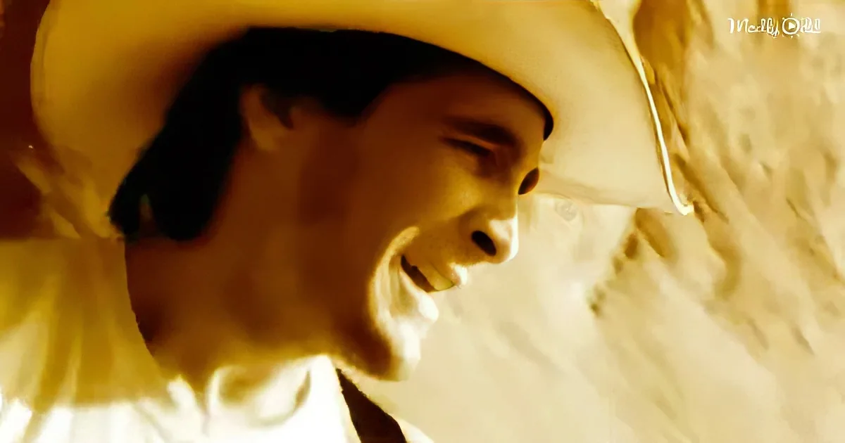 A person wearing a large yellow hat, looking down with a serene expression.