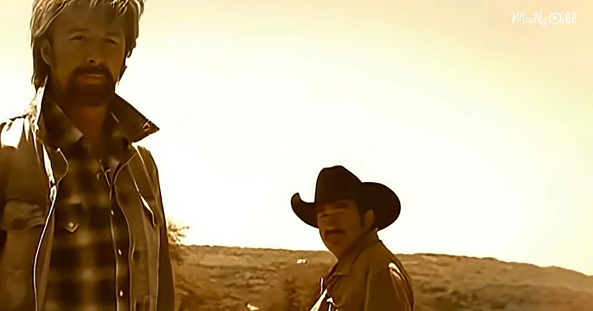 A man in a cowboy hat stands in a desert landscape, facing another man in a plaid shirt.