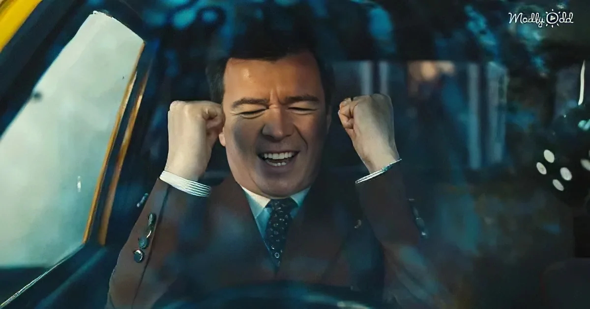A man in a suit celebrates with fists raised inside a car, surrounded by blurred lights.