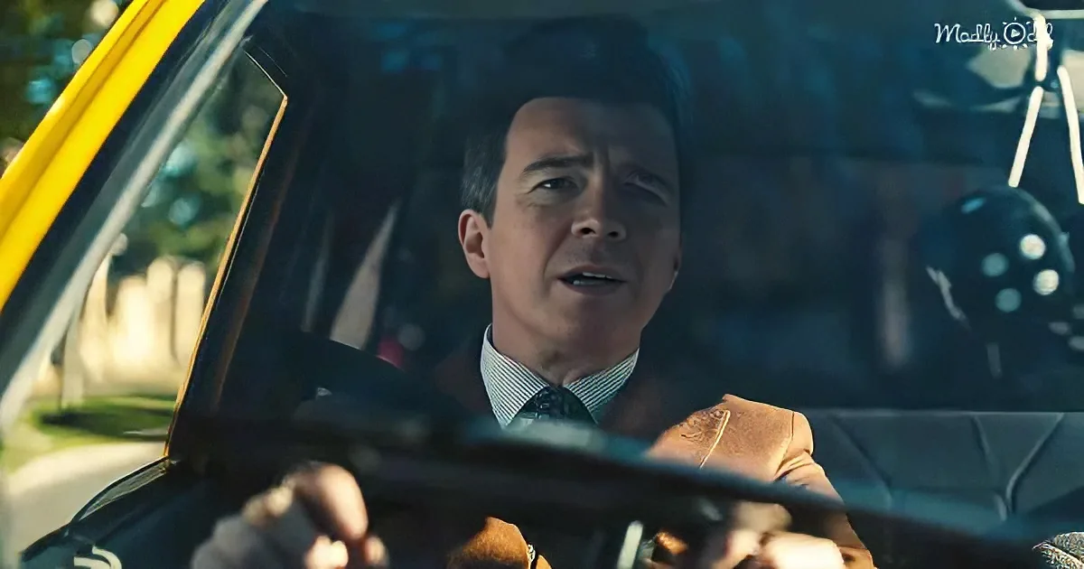 A man in a suit drives a yellow car, hands on the steering wheel, looking ahead.