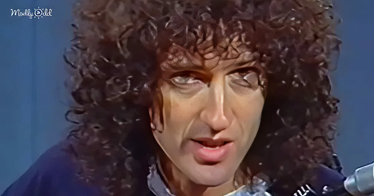 A person with curly hair and a blue shirt is seen in a close-up shot.