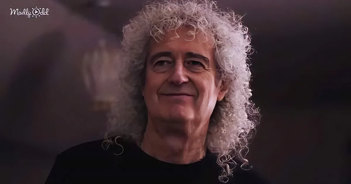 A smiling man with curly white hair and a black shirt, set against a dark background.
