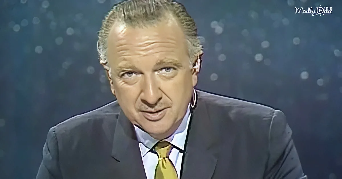A man in a suit and tie, looking to the side, with a dark background and bokeh effect.