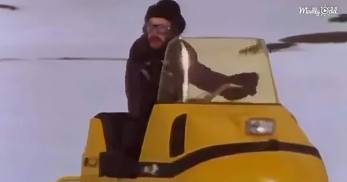 A man in a black outfit and helmet is riding a yellow snowmobile in a snowy landscape.