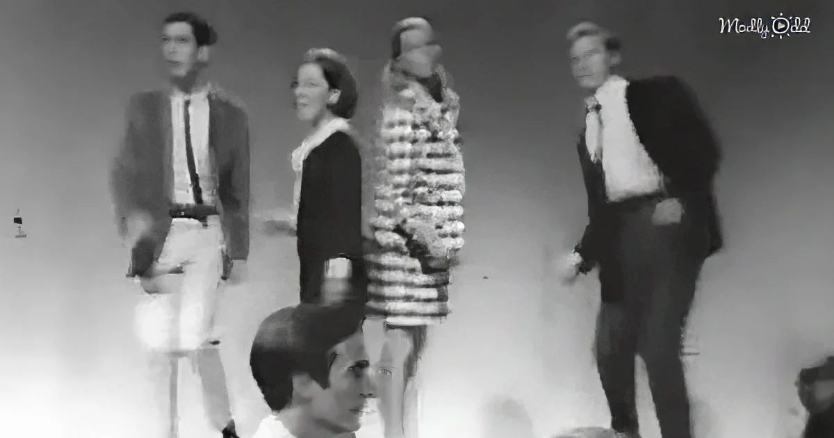 A group of people in a vintage setting, possibly a fashion show or performance, with one person in a striped dress...