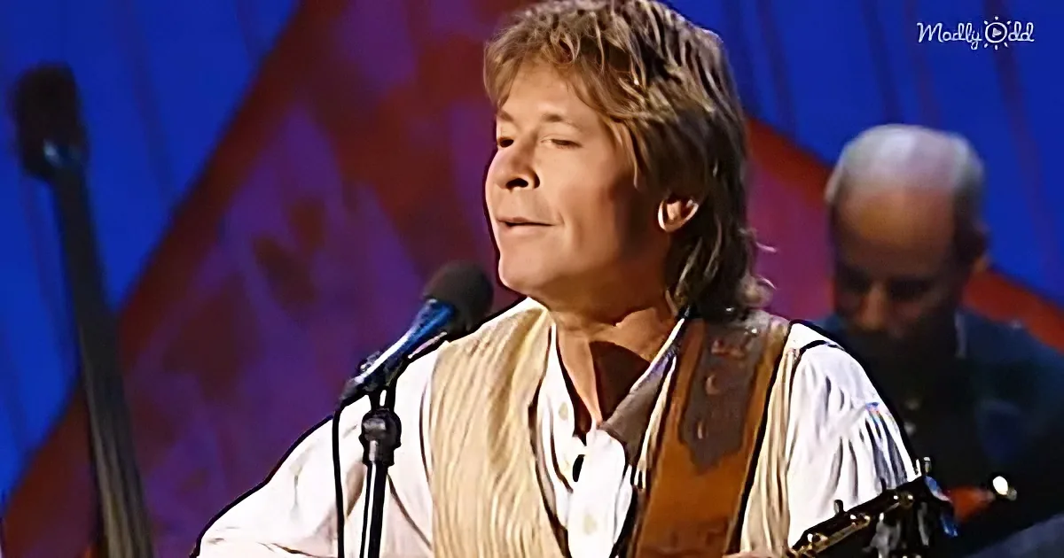 A man with long hair, wearing a white shirt and vest, sings into a microphone while holding a guitar.